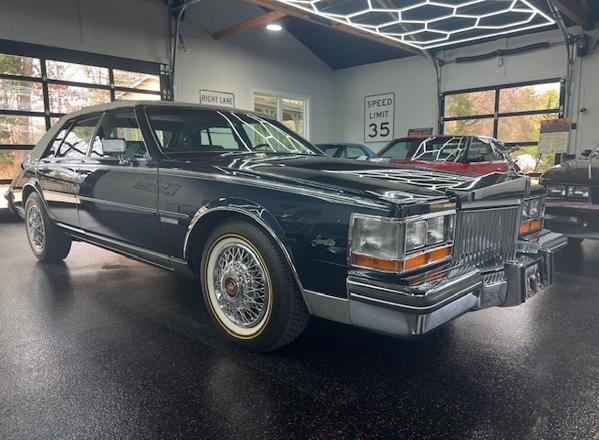1982 Cadillac Seville — black with white vinyl roof in showroom garage